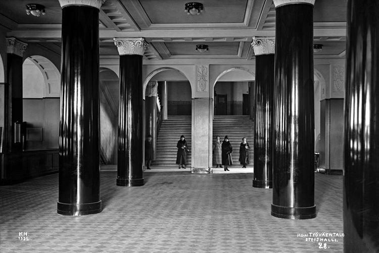 Black and white photograph of the main entrance of Työväen talo, looking towards the main staircase.