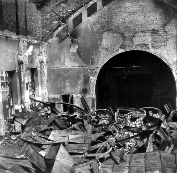 Black and white photograph of the hall after bomardment looking towards the stage.